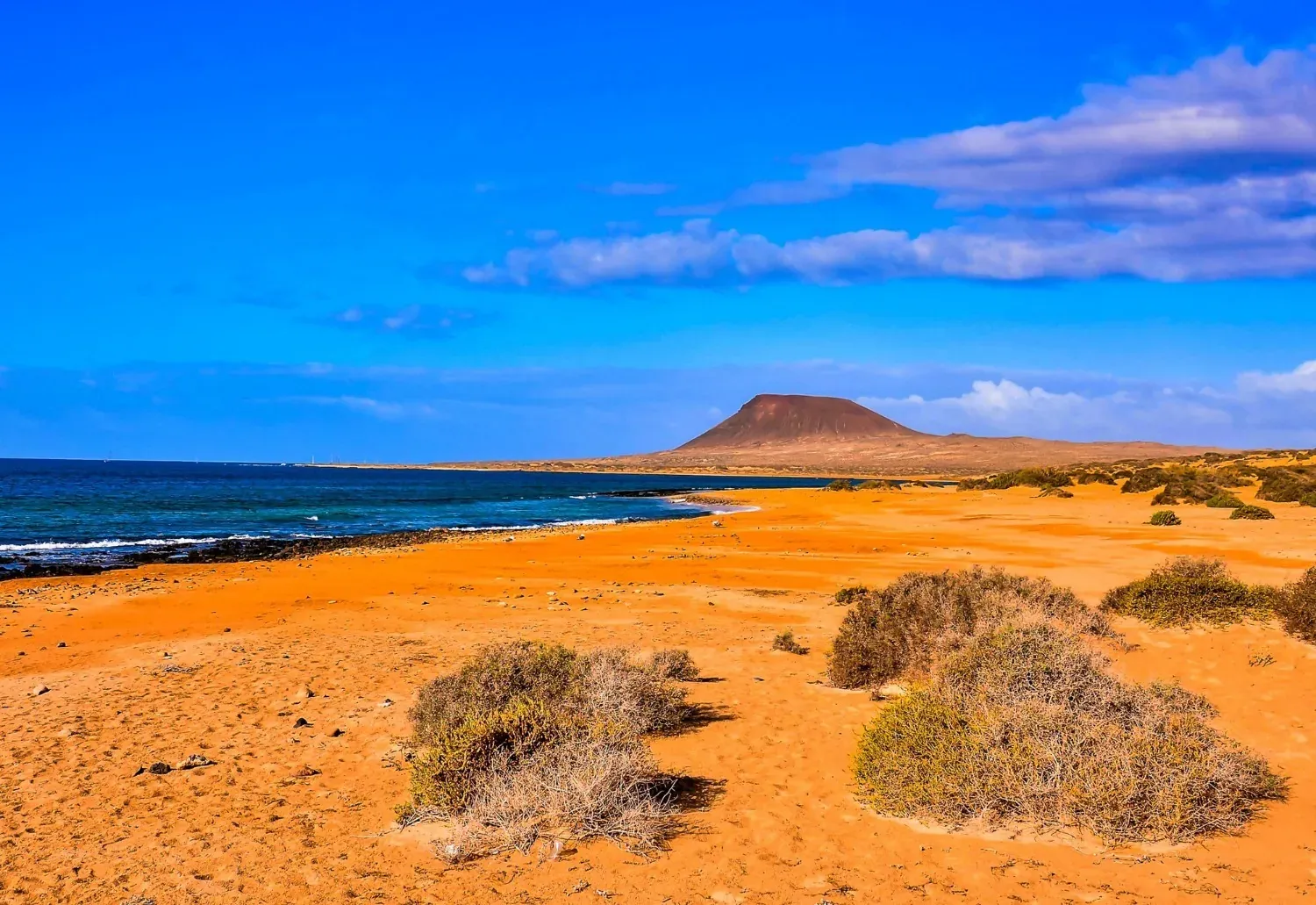 Spiaggia vulcanica e mare blu, perfetta per eventi aziendali di R2 Hoteles.