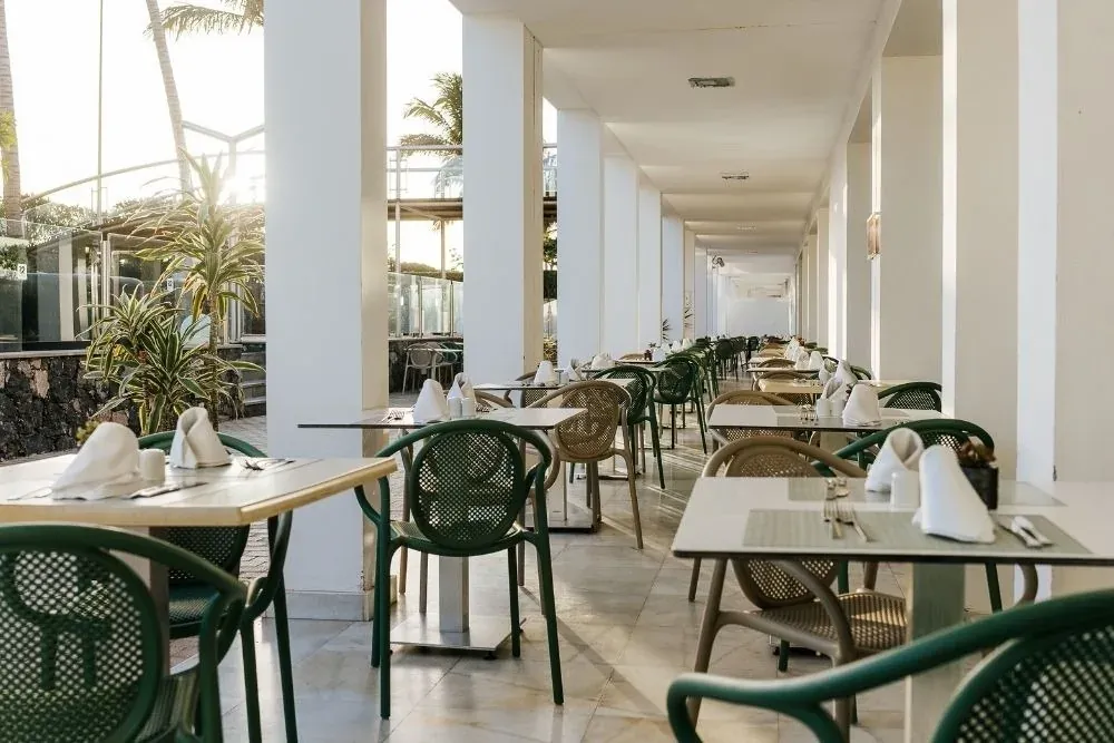 R2 Hoteles: Terraza de restaurante con mobiliario dispuesto para comidas al aire libre.