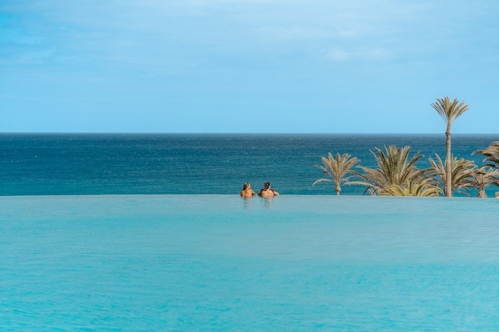 une table avec des assiettes et des couverts et une nappe avec des poissons et des vagues