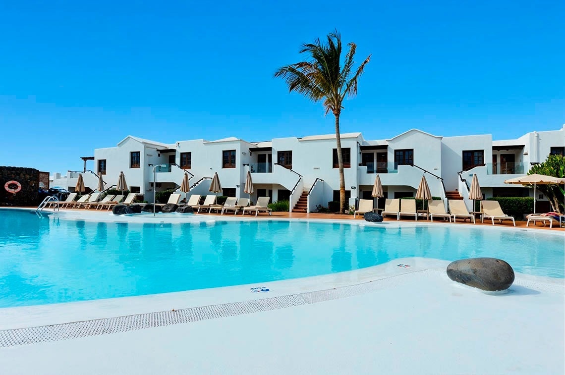 a white chair sits next to a tall white table