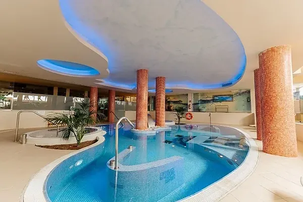 R2 Hoteles: Corporativo - Relajante piscina cubierta con jacuzzi y cascada, ideal para eventos corporativos.
