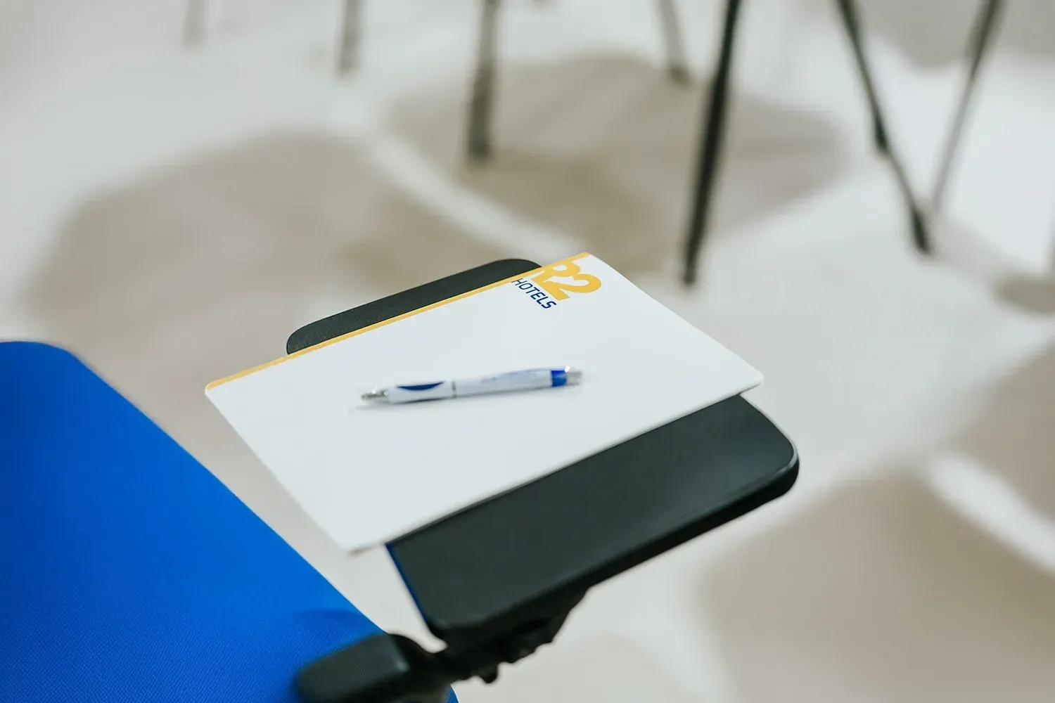 R2 Hotels: Schreibtisch mit Notizblock und Stift für Geschäftsreisen.