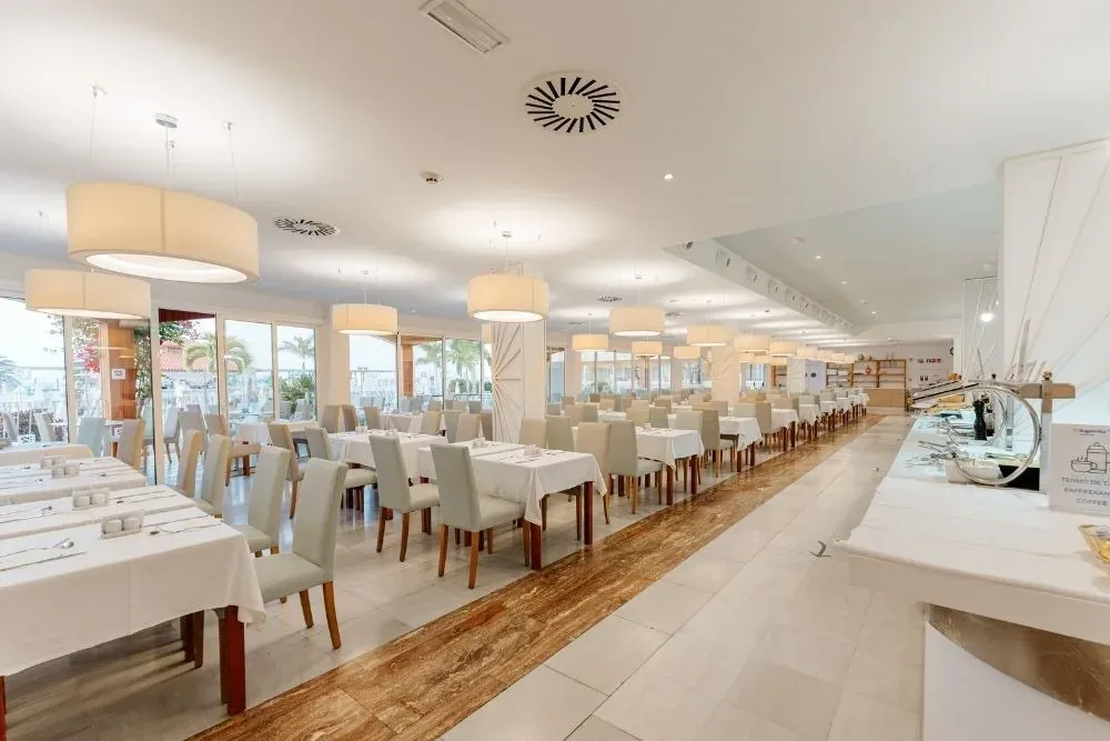 R2 Hoteles: Elegante salón corporativo con disposición de mesas listas para eventos.