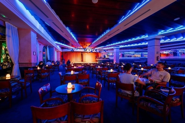 a woman wearing sunglasses is sticking her tongue out in a swimming pool