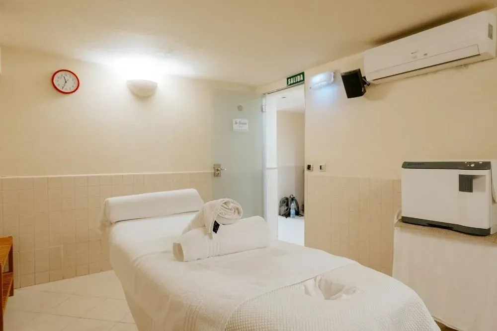 Sala corporativa R2 Hoteles para tratamientos, equipada con camilla y toallas.