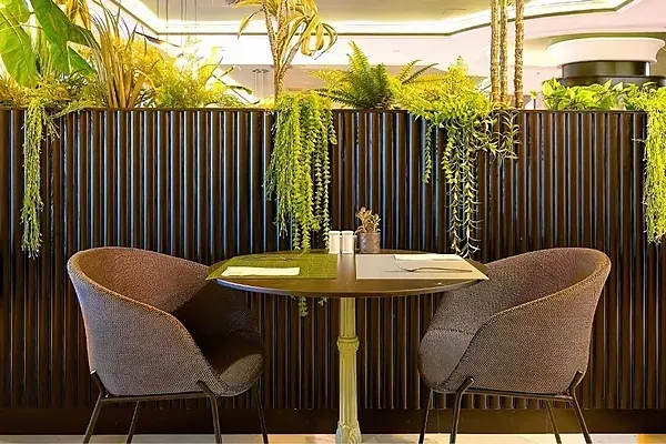 R2 Hotels: Modernes Restaurant mit grünen und orangen Stühlen.