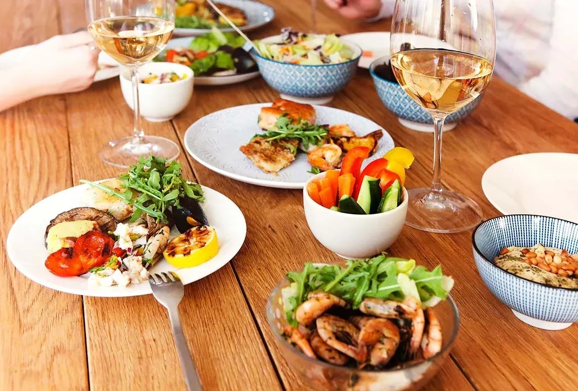 R2 Hotels: Gehobenes Outdoor-Dinner mit Meeresfrüchten, Wein und Salaten.