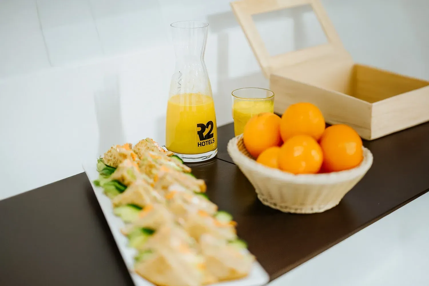 R2 Hotels: Firmen-Catering mit Sandwiches, Orangensaft und Obst.