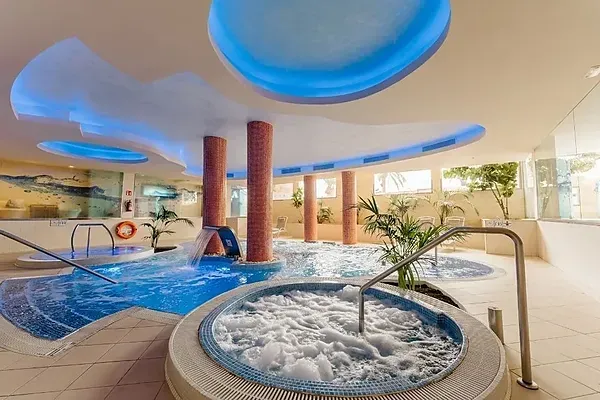 R2 Hoteles: Corporativo - Relajante piscina cubierta con jacuzzi y cascada, ideal para eventos corporativos.