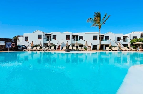 a white chair sits next to a tall white table