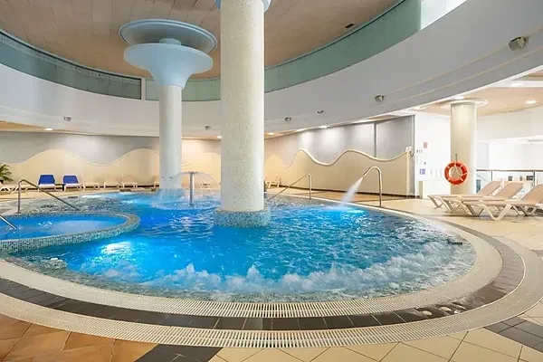 R2 Hoteles: Corporate indoor pool with waterfalls and jacuzzi.