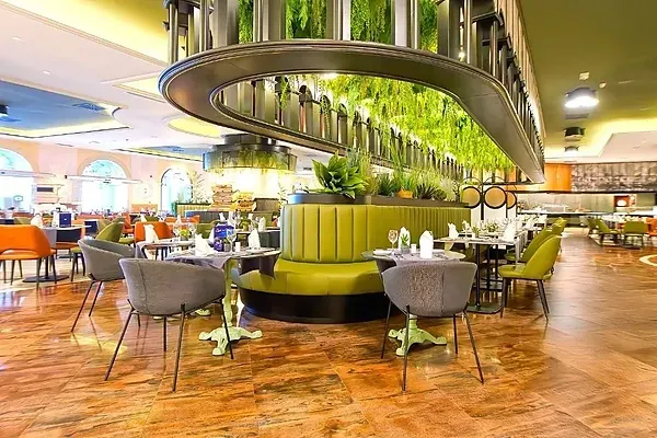 R2 Hotels: Modernes Restaurant mit grünen und orangen Stühlen.