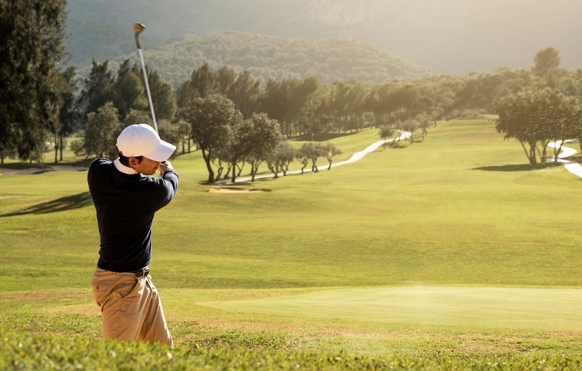 Golfista en Travel Raintree Corpo: swing perfecto en un campo verde y ondulado.