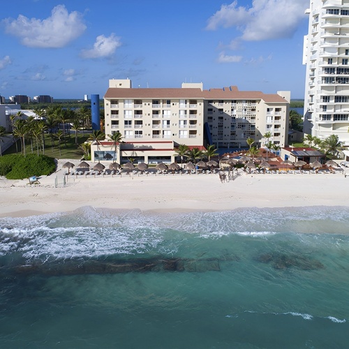 Travel Raintree Corpo resort: oceanfront hotel with beach, palm trees, and modern architecture.