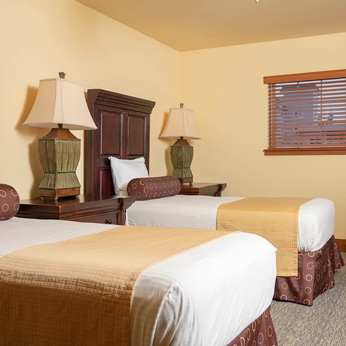 Travel Raintree Corpo: Two twin beds in a cozy hotel room with warm decor.