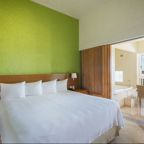 Travel Raintree Corpo hotel room with a spacious bed and balcony.