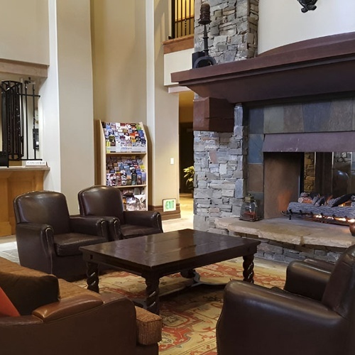 Travel Raintree Corpo hotel lobby with fireplace and plush leather armchairs. Ideal for travelers.