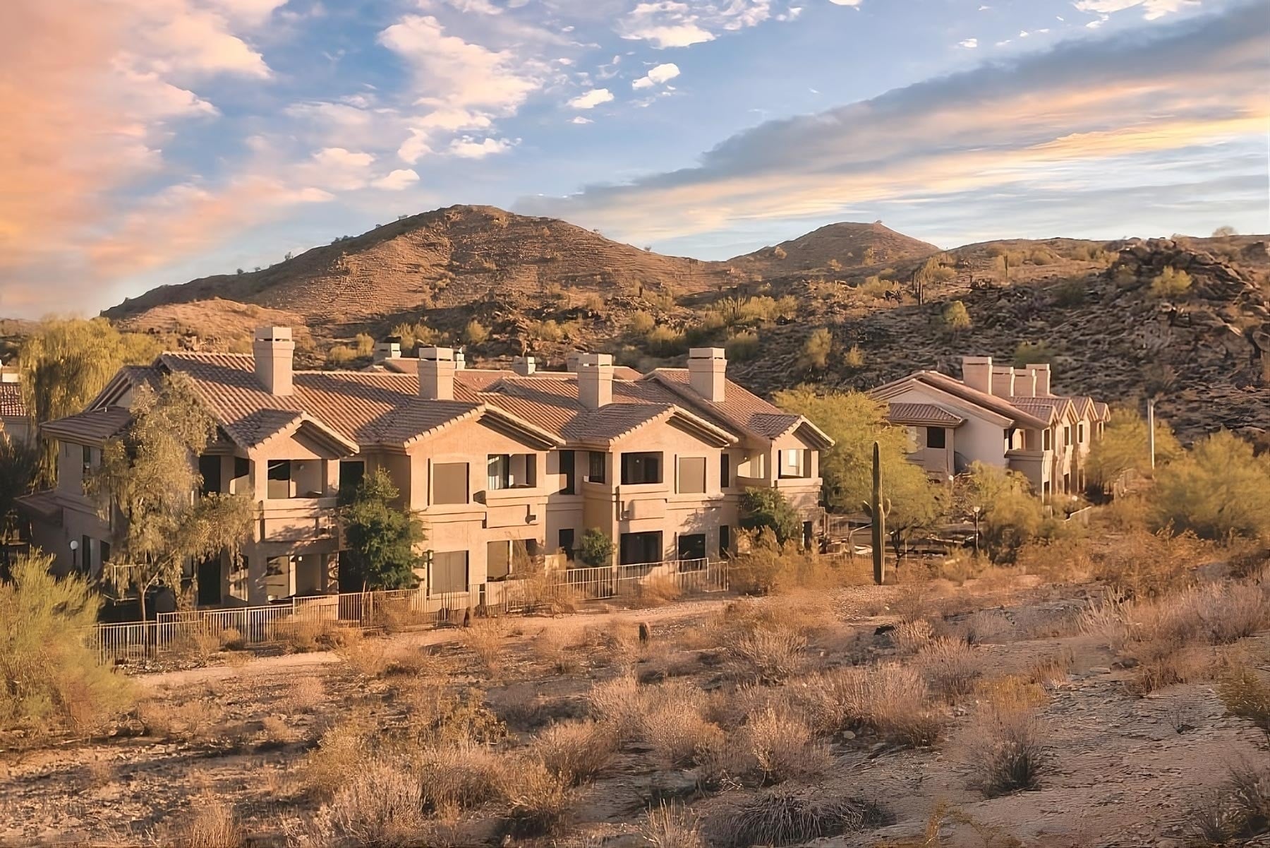Travel Raintree Corpo: Desert resort with mountains and sunset sky.