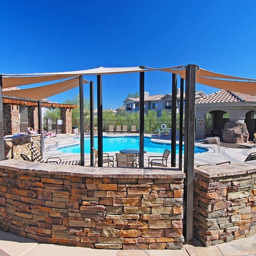 Travel Raintree Corpo: Outdoor pool with shade structure and stone seating area.