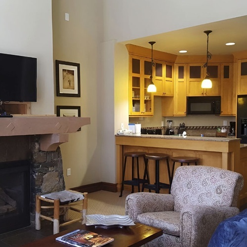 Cozy living room with fireplace and kitchen for your Travel Raintree Corpo stay.