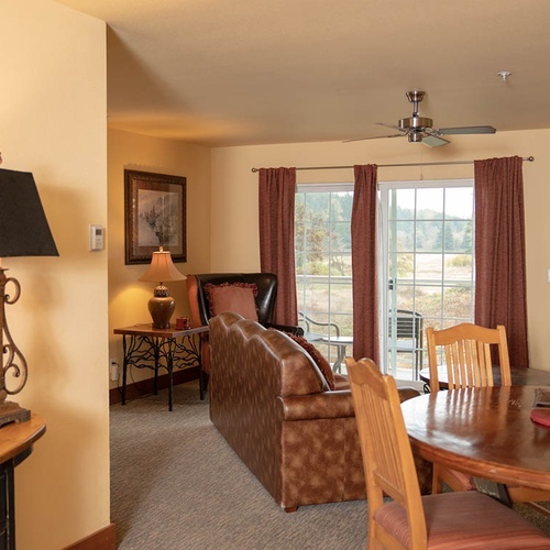 Cozy Travel Raintree Corpo living room with fireplace and outdoor view.