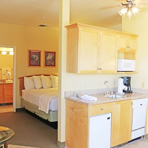 Travel Raintree Corpo suite with bed, kitchenette, and accessible bathroom.