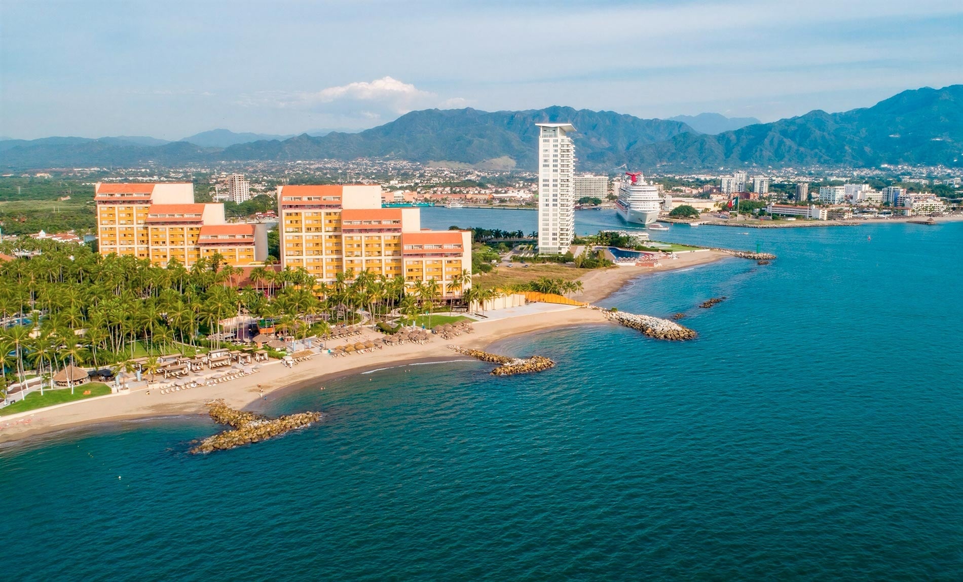 Travel Raintree Corpo: Resort with palm trees and mountain backdrop.