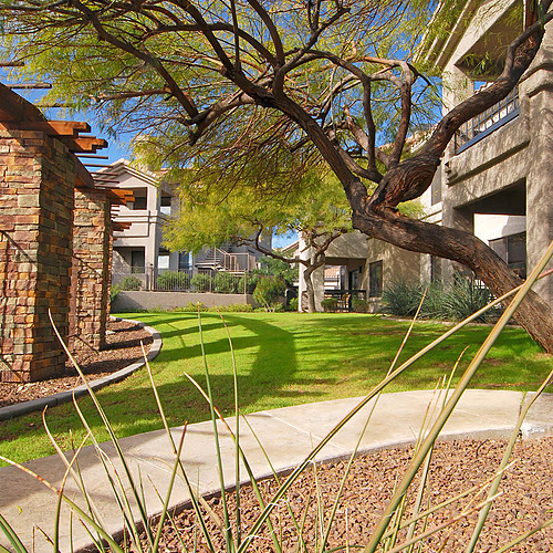 Travel Raintree Corpo: Apartment complex with trees and green lawn.