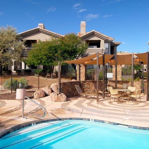 Travel Raintree Corpo: Bright blue pool and shaded seating area with tables.