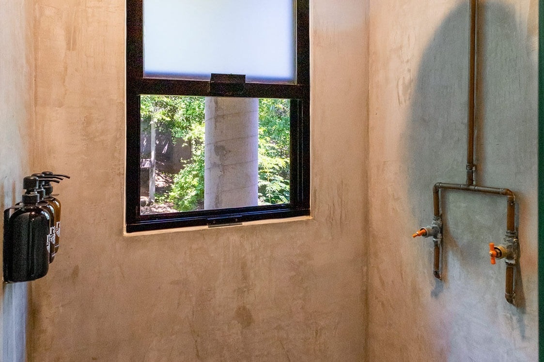 a bathroom with a window and a few bottles on the wall