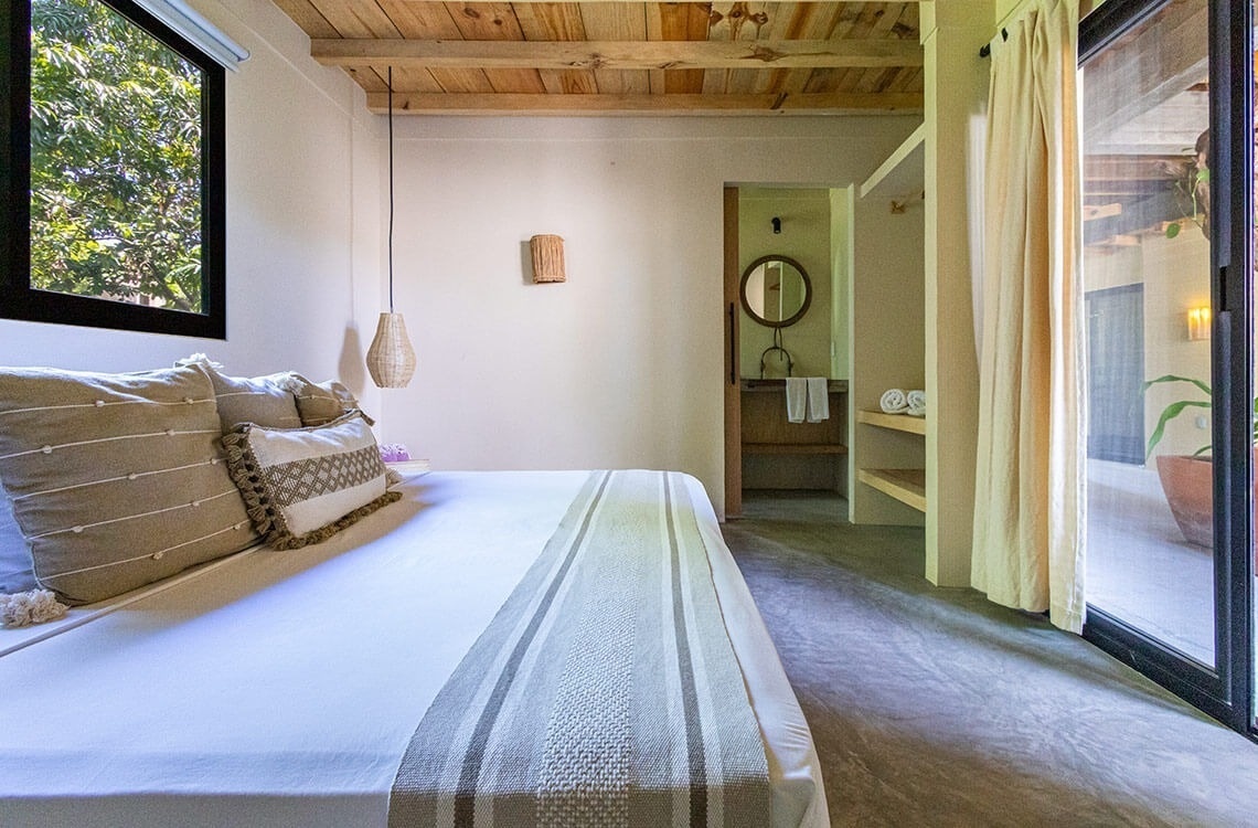 a bedroom with a sliding glass door leading to a bathroom