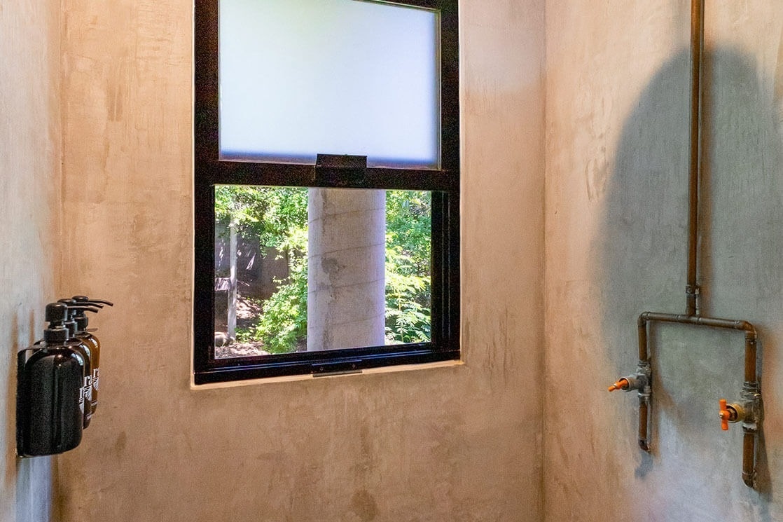 a bathroom with a window and two soap dispensers