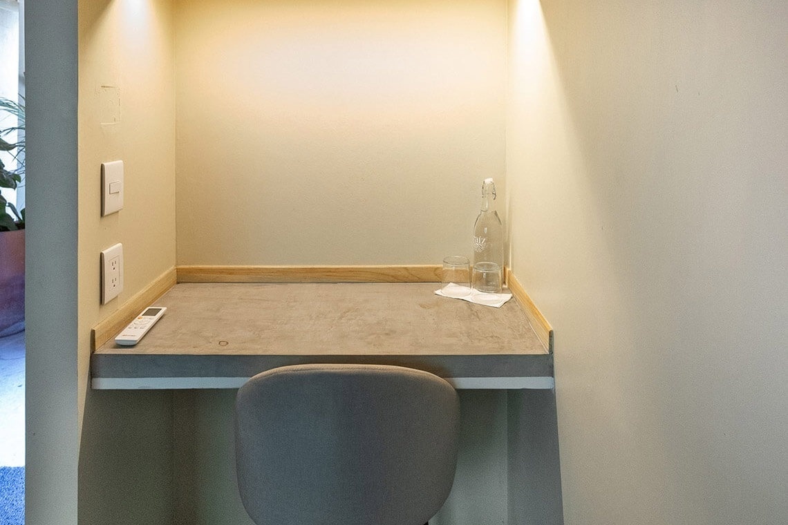 a small desk with a bottle of water and a glass on it