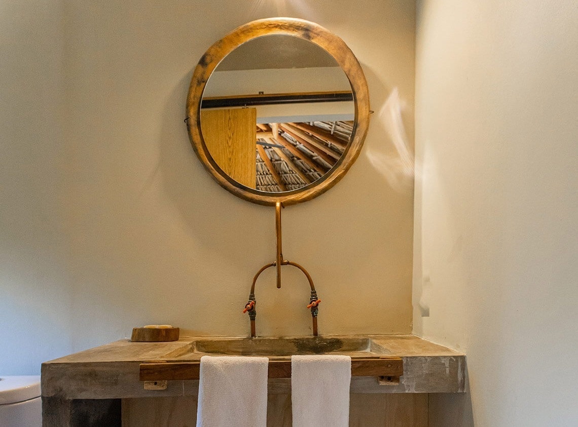 a bathroom sink with a wooden mirror above it