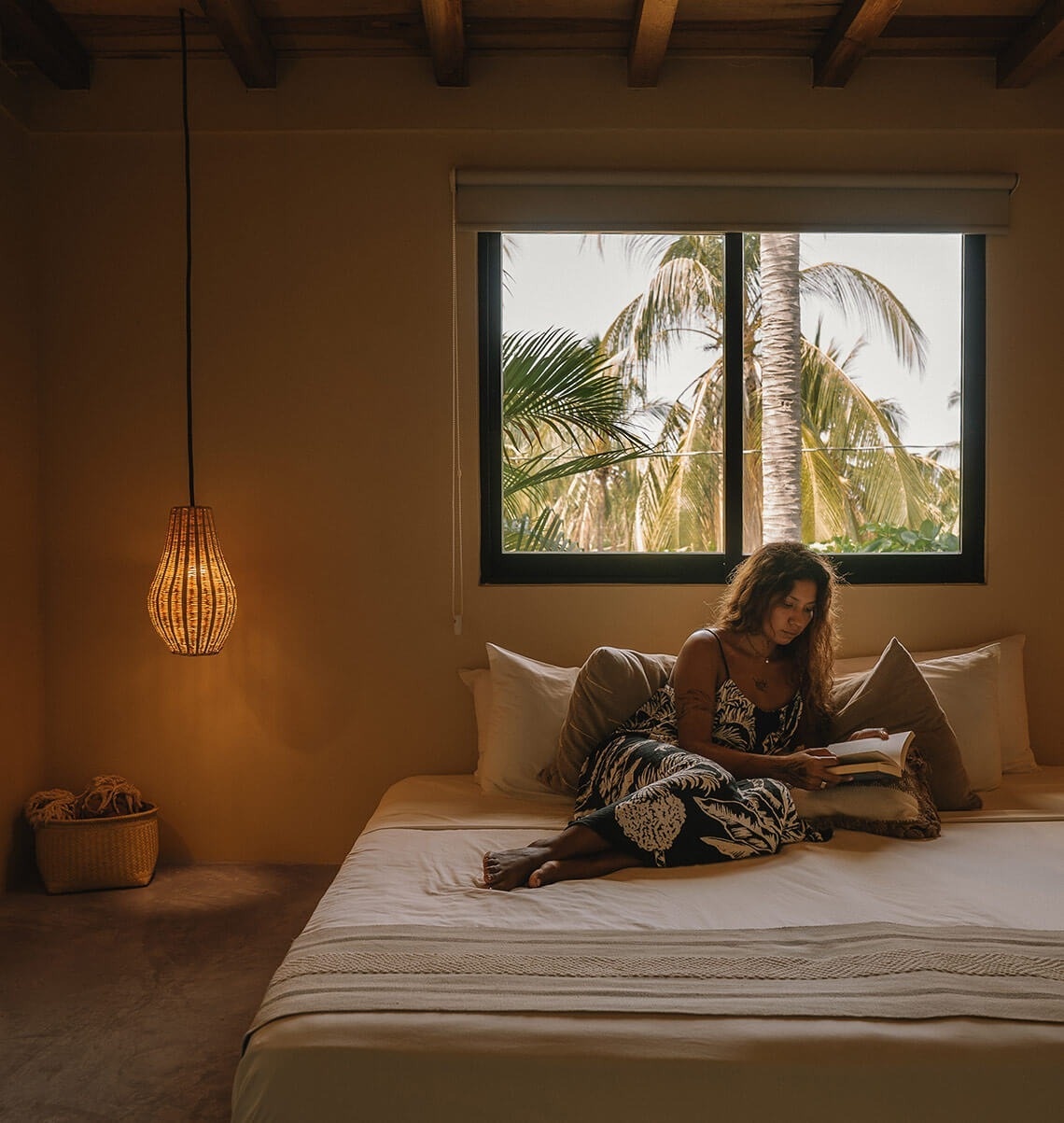 una mujer está sentada en una cama leyendo un libro