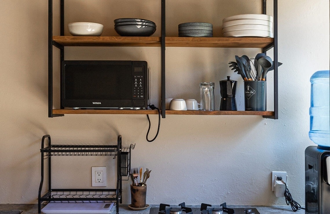 una cocina con microondas y estantes de madera