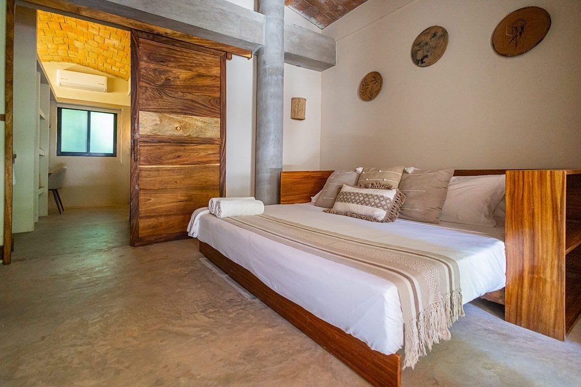 a bedroom with a bed and a television on the wall