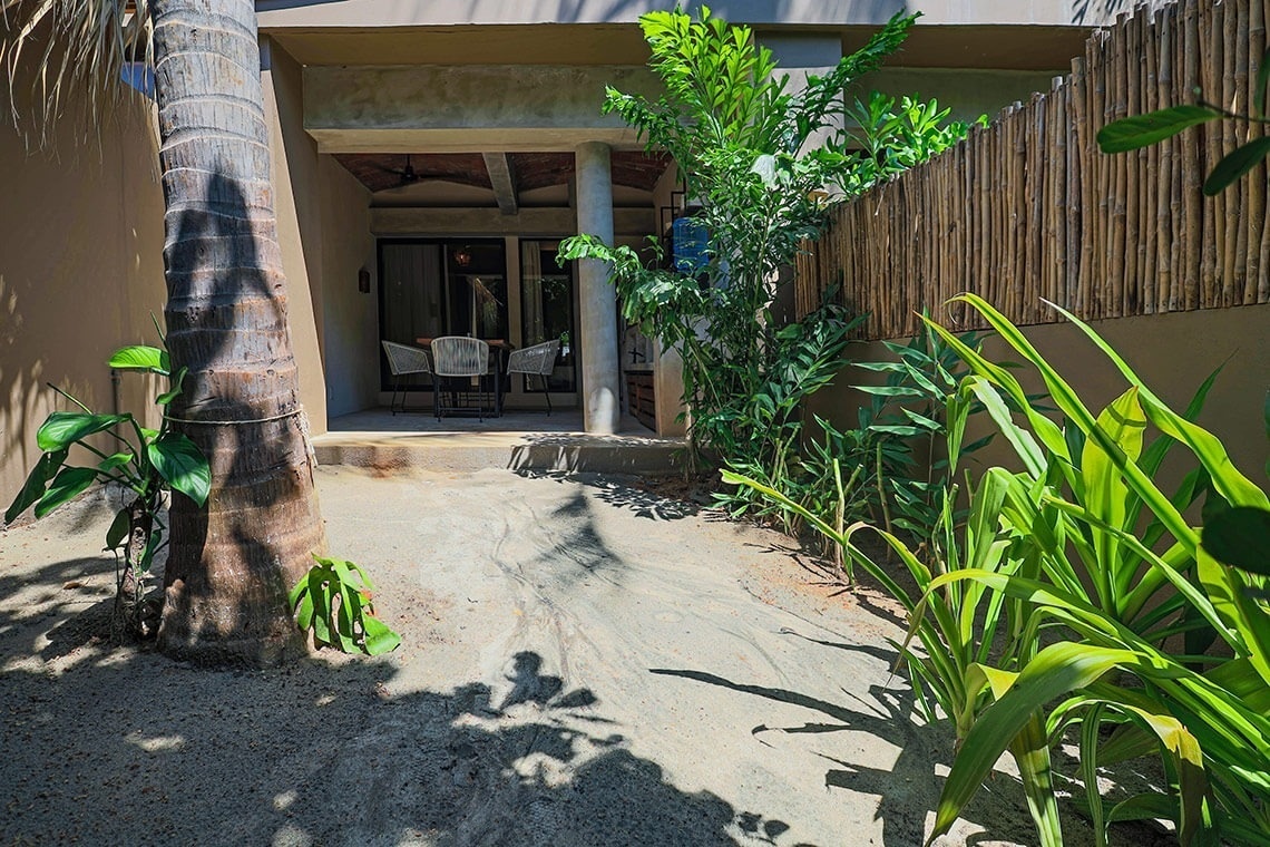 a patio with a table and chairs is surrounded by plants