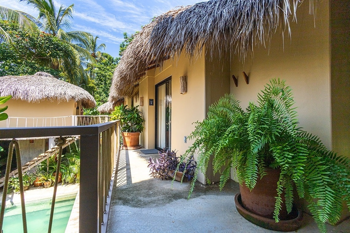 a balcony with a thatched roof and a sign that says ' a ' on it