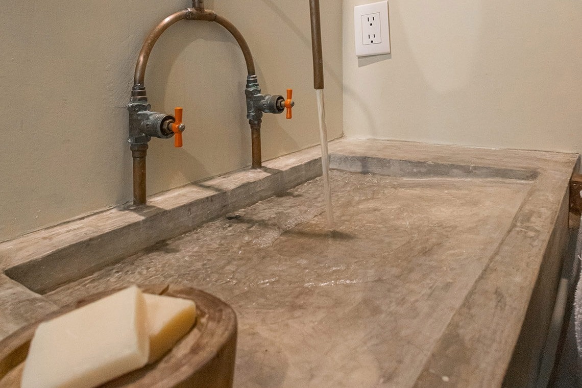 a bathroom sink with two faucets that have orange handles