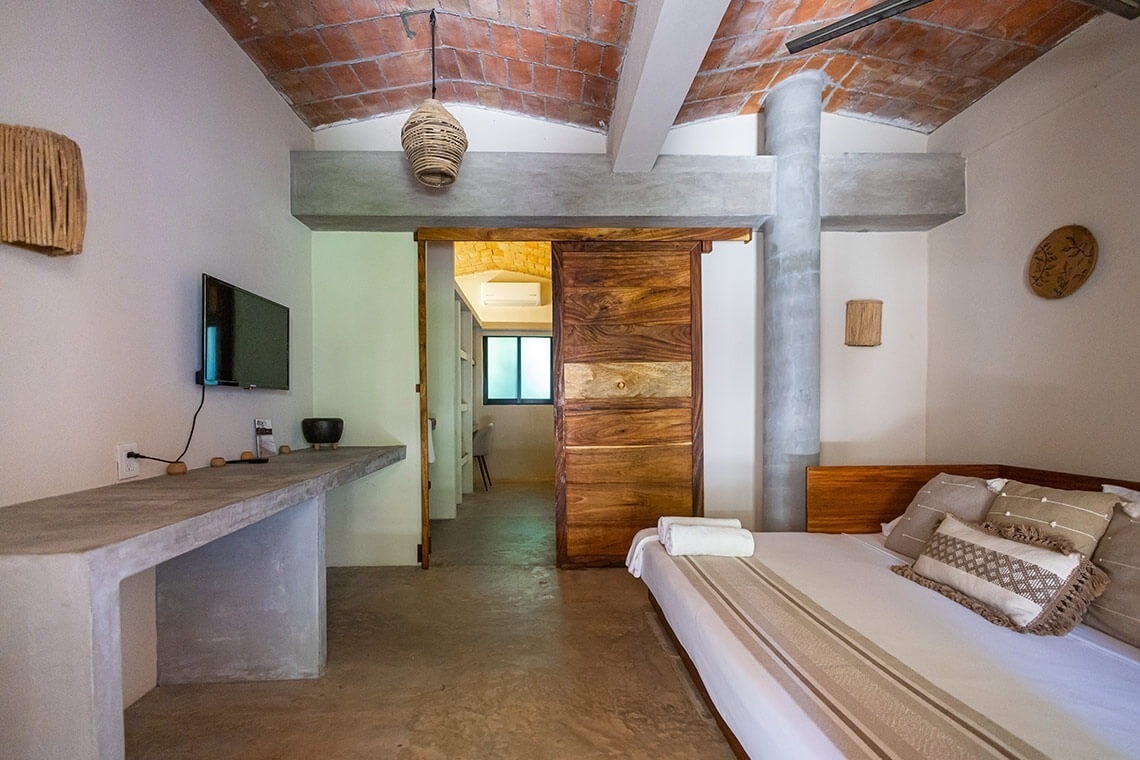 a bedroom with a bed and a television on the wall