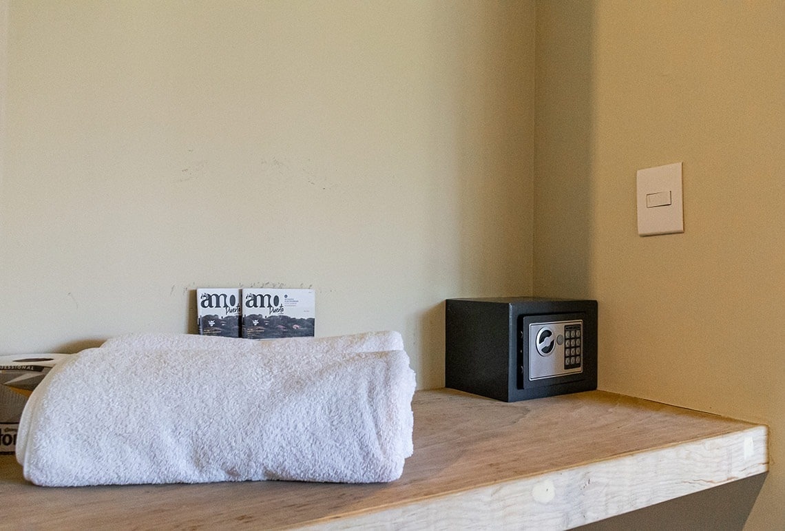 a stack of towels sits on a shelf next to a safe