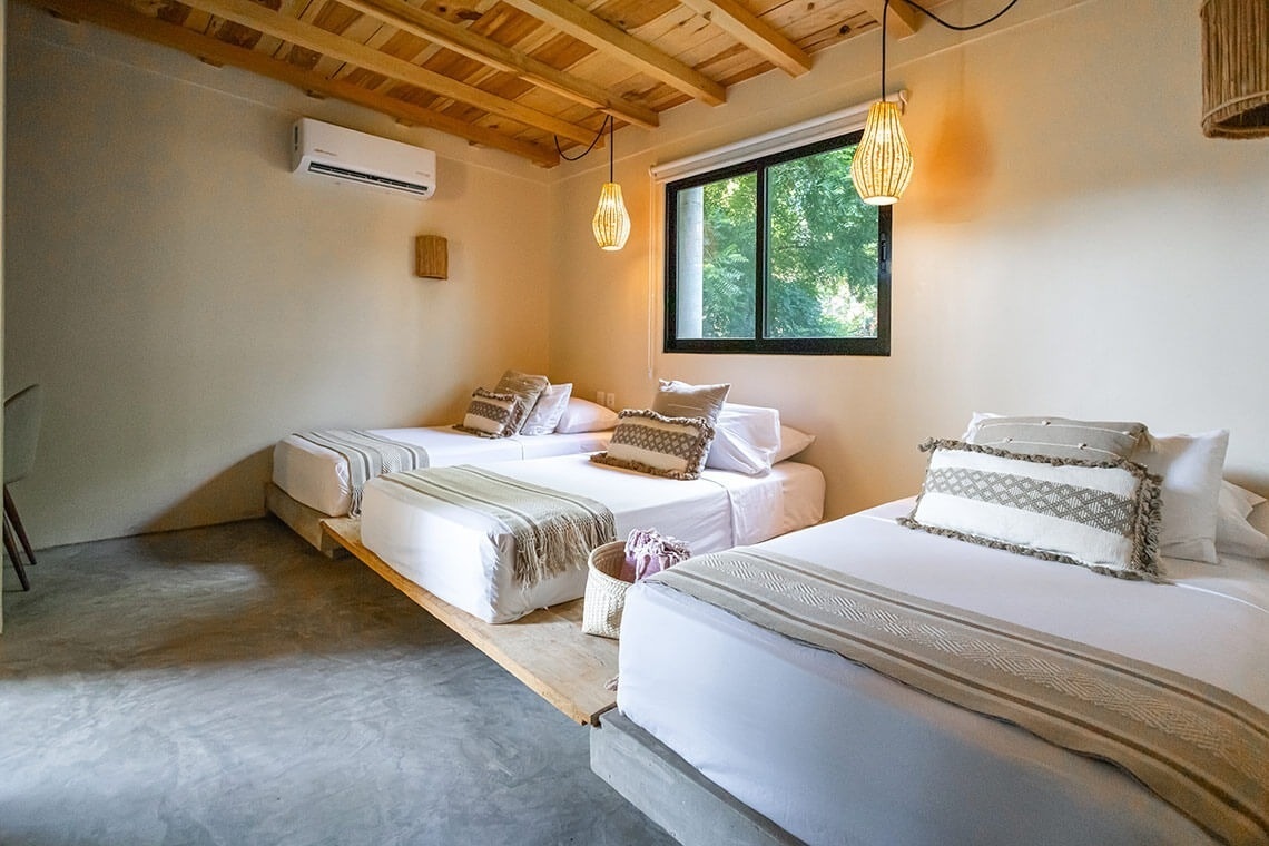 a bedroom with three beds and a window