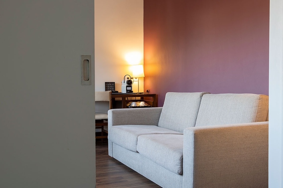 un canapé est assis dans une pièce avec un mur violet