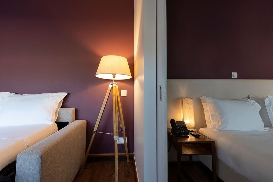 una habitación con dos camas y una lámpara de pie