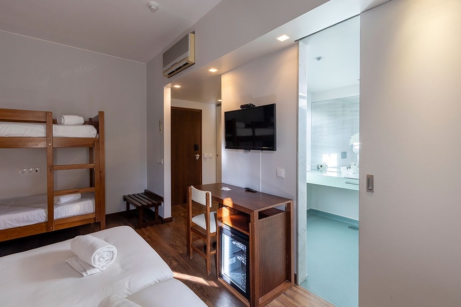 une chambre d' hôtel avec des lits superposés et une télévision