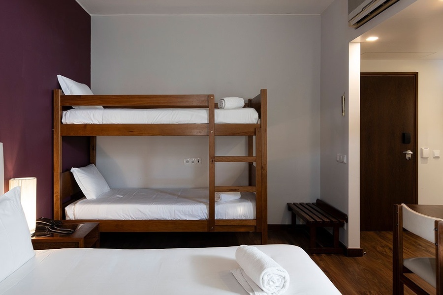 a hotel room with bunk beds and a purple wall