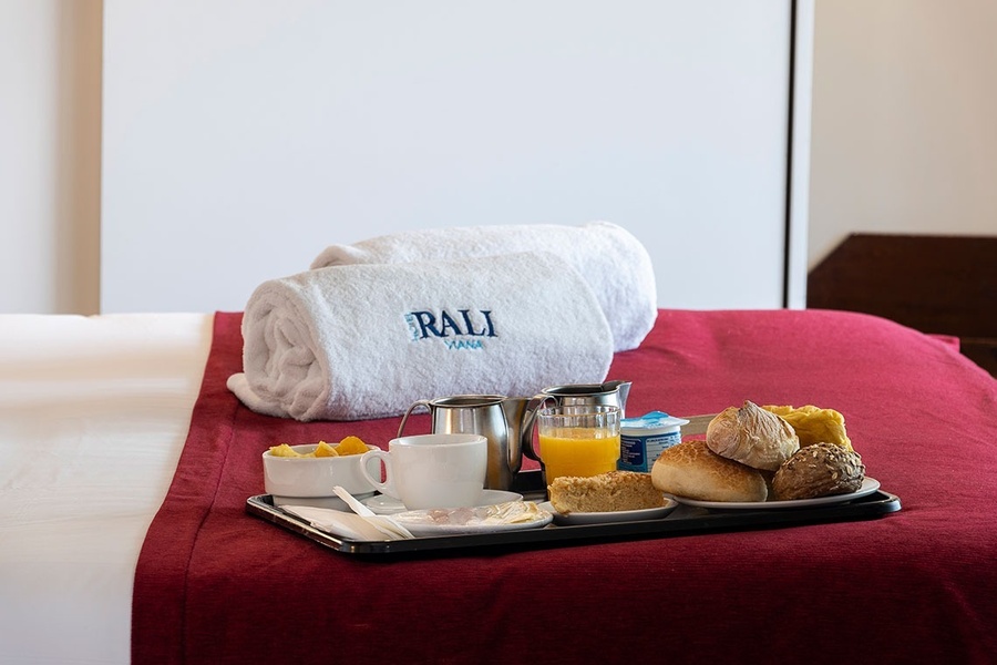a bed with a tray of food and a towel that says bali