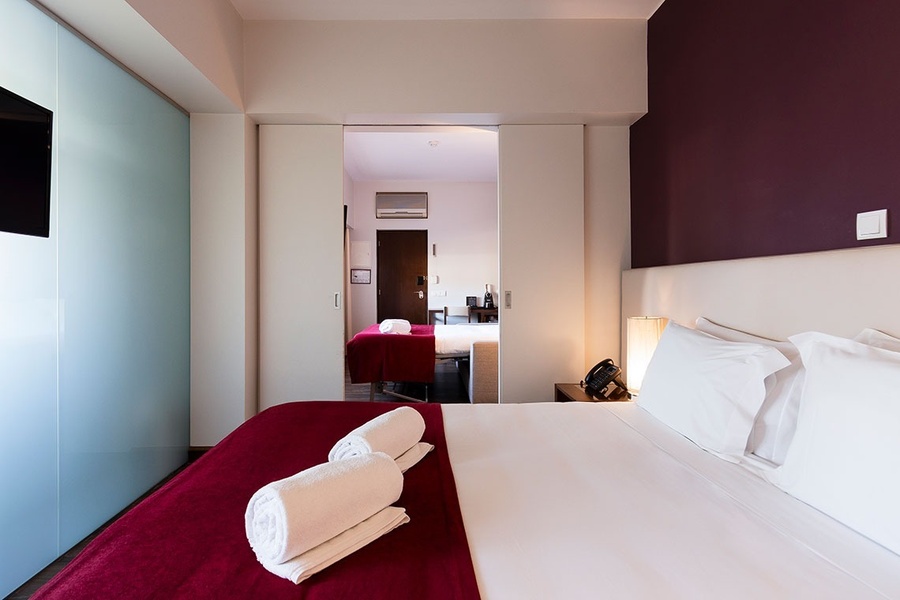 um quarto de hotel com uma cama e uma porta de vidro
