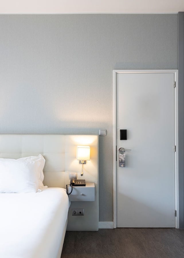 a hotel room with a bed and a door
